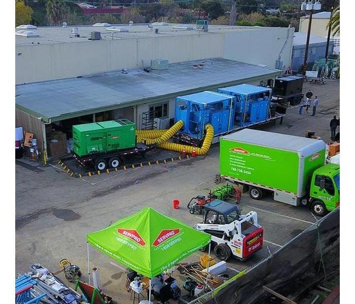 Aerial view of a job with green trucks and green generator.