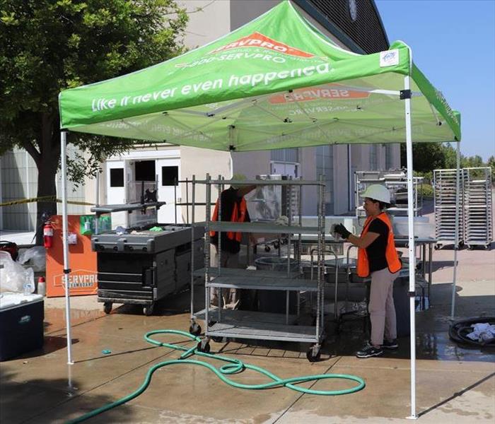 Crew cleaning contents at a middle school under a SERVPRO easy up.